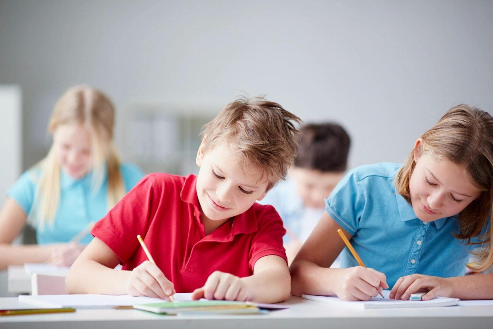 A group of children sitting at a table writing.