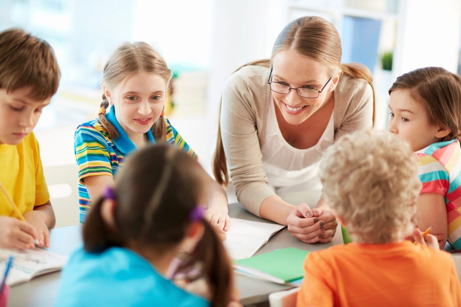 A woman and two girls are sitting in front of some papers.