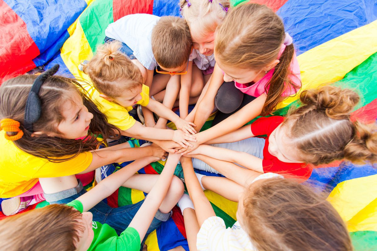 A group of children holding hands in the middle of a circle.